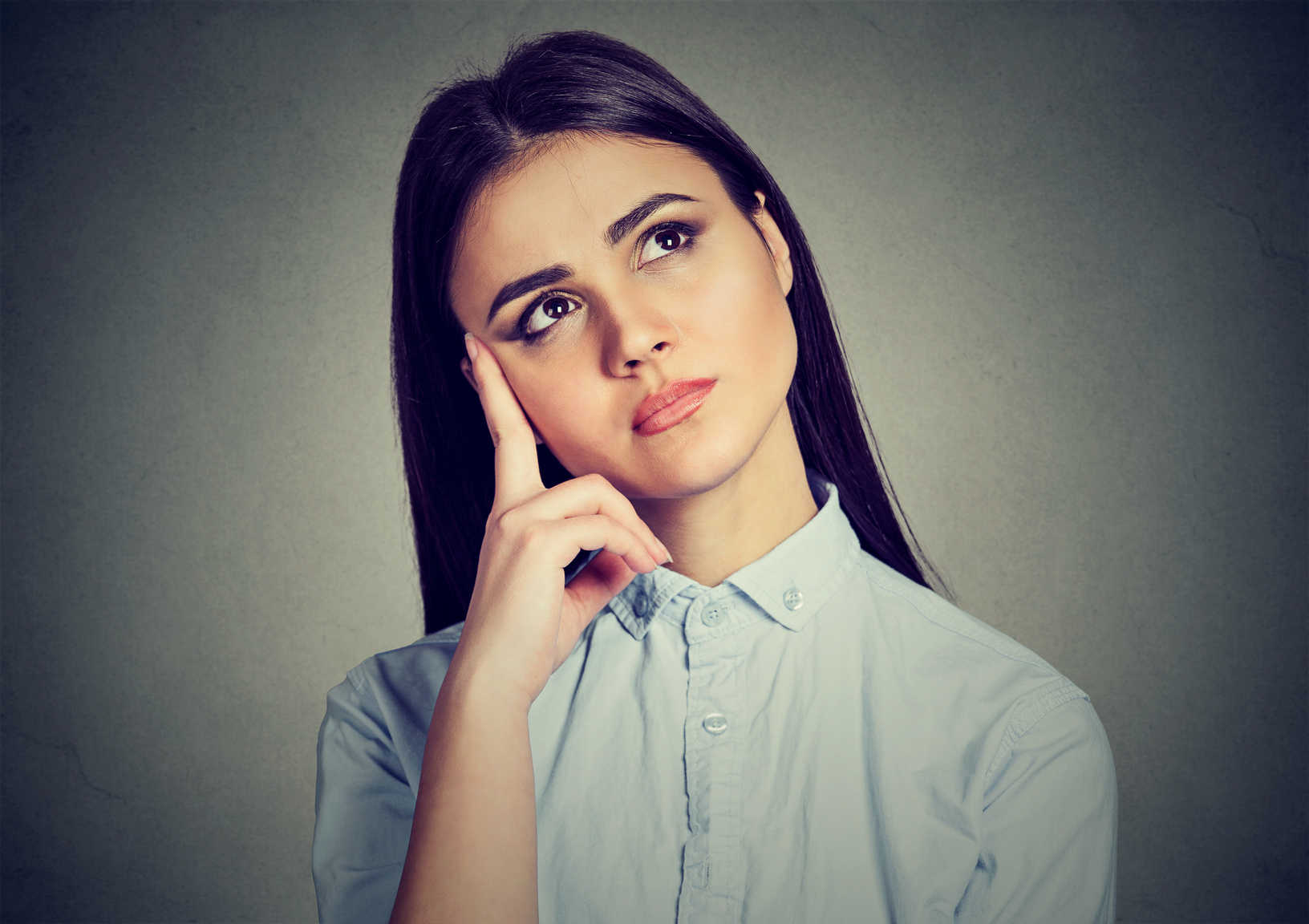 Pensive young woman in doubts